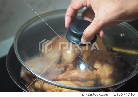 Cooking chicken in a pot on a stove in the kitchen 135574710