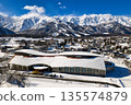 Kyowa Wing Hakuba (Wing 21) and the Hakuba mountain range, with snow rising from it. Hakuba Village, Nagano Prefecture (aerial photo taken by drone) 135574879