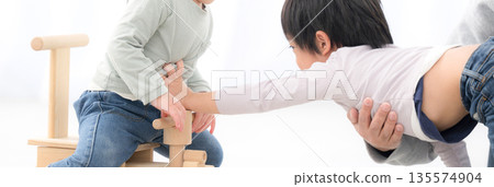 Image of siblings fighting over a toy - no faces 135574904