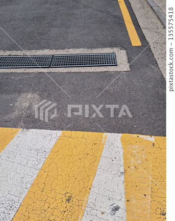 It is an asphalt road with a drain. It is an asphalt road with a drain. 135575418