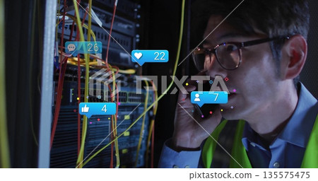 Calling vest-wearing tech using smartphone in server room, with rack cables and icons, copy space Calling vest-wearing tech using smartphone in server room, with rack cables and icons, copy space 135575475