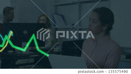 Colleagues collaborating in office while woman in pink polka-dot blouse holding laptop, copy space 135575490