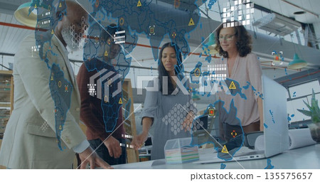 Collaborating team wearing suits reviewing plans at loft-style office, with laptop and blueprints Collaborating team wearing suits reviewing plans at loft-style office, with laptop and blueprints 135575657