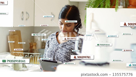 Interacting adult woman studying data overlays on tablet computer in home kitchen, with dish rack Interacting adult woman studying data overlays on tablet computer in home kitchen, with dish rack 135575776