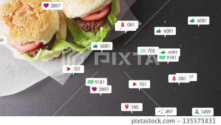 Showing two sesame burgers resting on paper at table, with floating notification icons, copy space 135575831