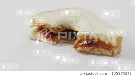 Displaying half-eaten white bread peanut butter and jelly sandwich on surface with notifications Displaying half-eaten white bread peanut butter and jelly sandwich on surface with notifications 135575871