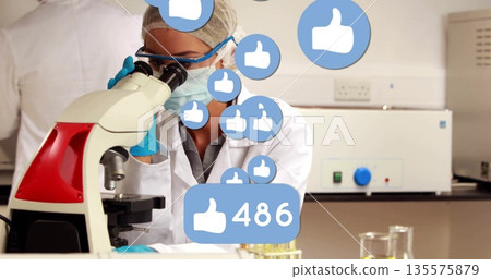 Observing scientist wearing coat examining microscope in lab, liquid test tubes and thumbs-up icons 135575879