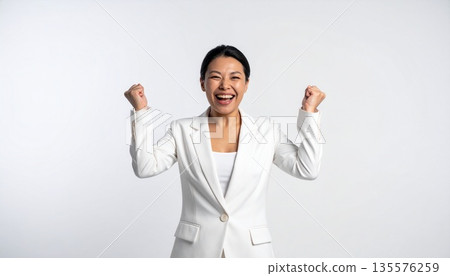 一位身穿西裝的女子高舉雙手，欣喜不已。 135576259