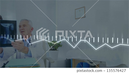 Senior doctor in white coat reviewing x-ray film in exam room, with stethoscope and graph overlay Senior doctor in white coat reviewing x-ray film in exam room, with stethoscope and graph overlay 135576427