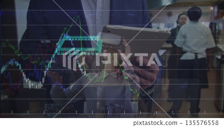 Guiding businessman in suit holding tablet and woman adjusting VR headset in bar with chart overlay Guiding businessman in suit holding tablet and woman adjusting VR headset in bar with chart overlay 135576558