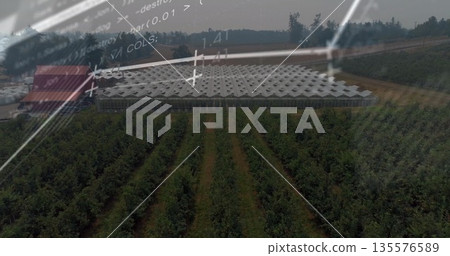 Displaying modern greenhouse with white patterned roof over orchard, with code and data overlays 135576589