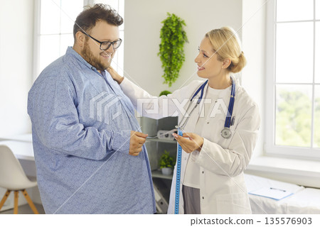 Friendly doctor discussing weight loss plan with obese male patient in clinic Friendly doctor discussing weight loss plan with obese male patient in clinic 135576903
