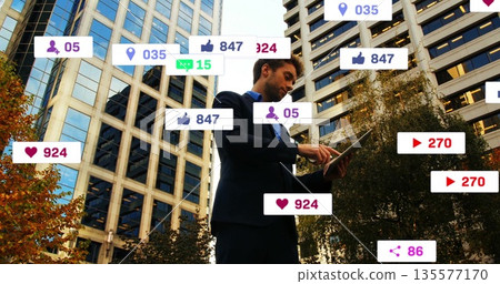 Tapping businessman wearing dark suit scrolling tablet at urban plaza, with floating social icons Tapping businessman wearing dark suit scrolling tablet at urban plaza, with floating social icons 135577170