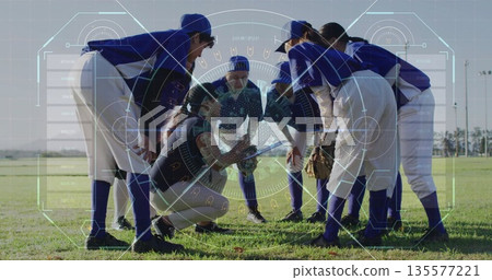 Gathering baseball players huddling on outfield grass in uniforms, with bat, gloves, catcher's gear 135577221