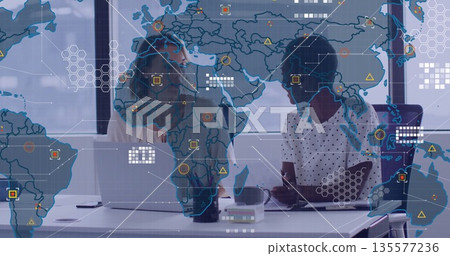 Collaborating colleagues analyzing map overlay on laptop at conference room, smartphone coffee mug 135577236