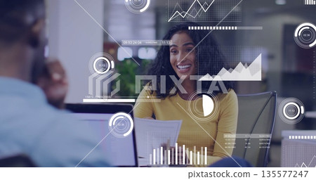 Presenting Hispanic woman holding printed reports at office desk, with laptop and data overlays Presenting Hispanic woman holding printed reports at office desk, with laptop and data overlays 135577247