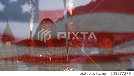 Two friends raising sparklers under translucent US flag overlay at waterfront dusk, plaid shirt Two friends raising sparklers under translucent US flag overlay at waterfront dusk, plaid shirt 135577270