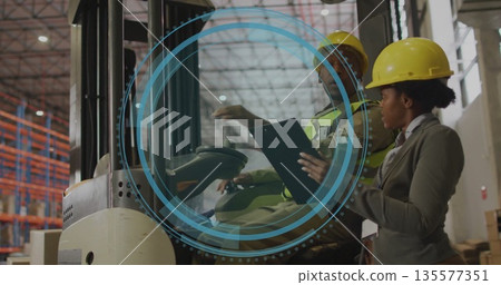 Forklift driver briefing supervisor in warehouse holding clipboard pen, wearing neon vest, hard hat Forklift driver briefing supervisor in warehouse holding clipboard pen, wearing neon vest, hard hat 135577351