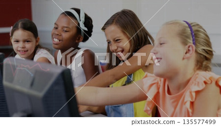 Pointing and smiling four female students using computers in school lab, with keyboards and mice Pointing and smiling four female students using computers in school lab, with keyboards and mice 135577499