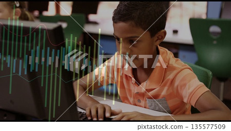 Typing student in orange striped polo focusing on desktop monitor in school lab, with keyboard Typing student in orange striped polo focusing on desktop monitor in school lab, with keyboard 135577509