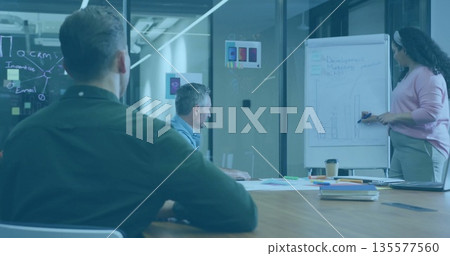 Colleagues presenting bar chart in meeting room, with flipchart markers, sticky notes and charts 135577560