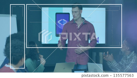Gesturing maroon-clad presenter presenting tablet interface in meeting room, with display screen Gesturing maroon-clad presenter presenting tablet interface in meeting room, with display screen 135577563