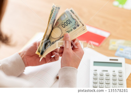 A middle-aged woman keeping a household account book A middle-aged woman keeping a household account book 135578281