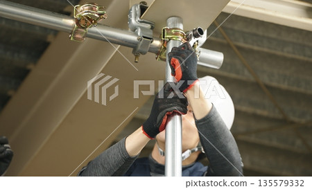 一名工匠正在安裝單根管道 135579332