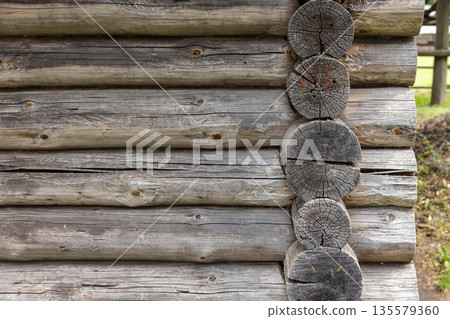 Close up view of a rustic log cabin wall showing stacked horizontal logs 135579360