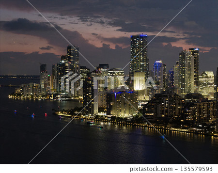 Famous landmarks of Miami Brickell from above at night. Drone view of the Brickell in Miami city. Business in Brickell district. Biscayne Bay Florida iconic urban coastline in daylight. 135579593