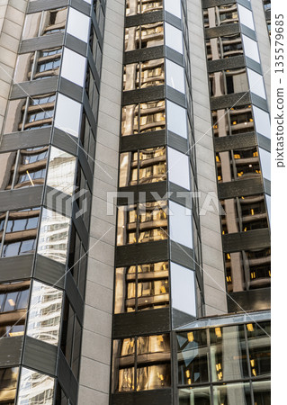 Glass building windows. Architectural detail. Background of architecture. Modern glass background. Glass exterior background. Business zone. Building exterior architecture. Building background Glass building windows. Architectural detail. Background of architecture. Modern glass background. Glass exterior background. Business zone. Building exterior architecture. Building background 135579685
