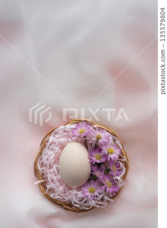 Easter Egg with Pink Flowers in Basket on Soft Pastel Background Easter Egg with Pink Flowers in Basket on Soft Pastel Background 135579804