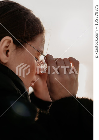 Girl Glasses Adjusting Outdoors Winter; Cold weather; Eyeglasses repair. 135579875