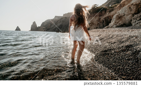 Woman Walking on a Beach at Sunset 135579881