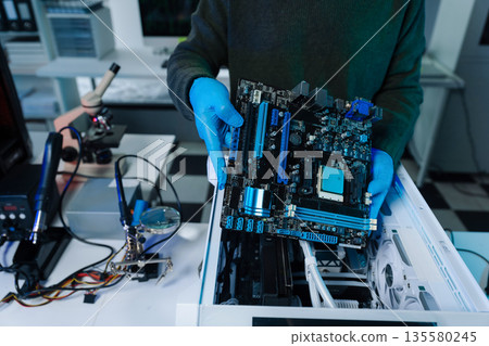 Hands repairing electronic devices. Electronic technician. 135580245