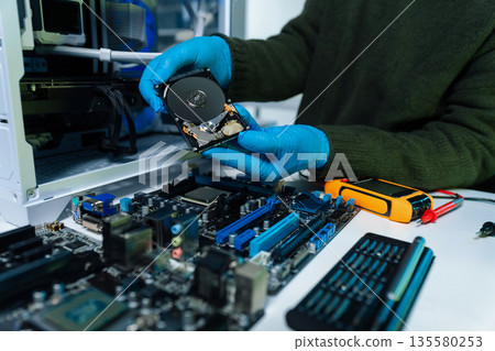 Hands repairing electronic devices. Electronic technician. Hands repairing electronic devices. Electronic technician. 135580253