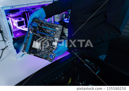 Hands repairing electronic devices. Electronic technician. Hands repairing electronic devices. Electronic technician. 135580258