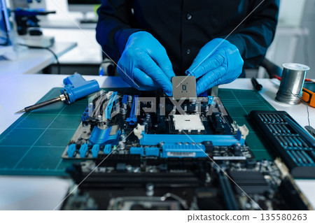 Hands repairing electronic devices. Electronic technician. Hands repairing electronic devices. Electronic technician. 135580263