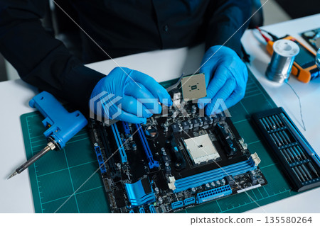 Hands repairing electronic devices. Electronic technician. Hands repairing electronic devices. Electronic technician. 135580264