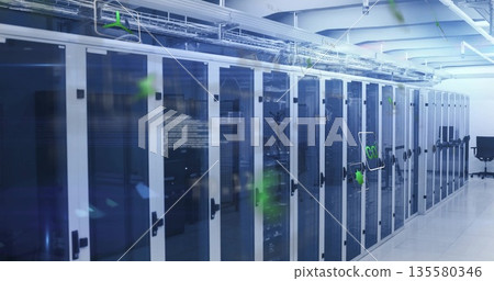 Displaying server cabinets with blue LEDs and cable trays in data center corridor, with black chair 135580346