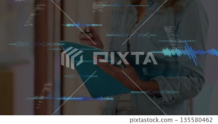 Teenage girl holding blue clipboard and pen and writing in studio, with waveforms and code snippets 135580462