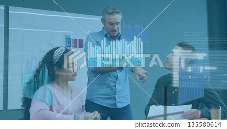 Presenting mature man gesturing at meeting room, with financial charts projected on whiteboard 135580614