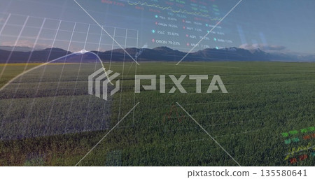 Displaying crop field across farmland near mountains, featuring overlay with line graph and tickers 135580641