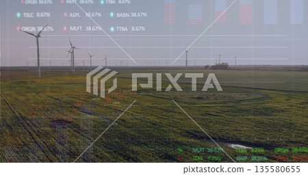 Showing wind turbines spinning over green farmland, with semi-transparent stock ticker overlay 135580655