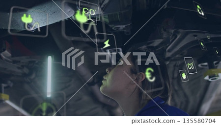 Coveralls-clad mechanic examining undercarriage in garage, with LED lamp and icons, copy space Coveralls-clad mechanic examining undercarriage in garage, with LED lamp and icons, copy space 135580704