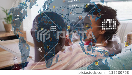 Couple in casual clothes holding bottle while snacking in living room with holographic map overlay Couple in casual clothes holding bottle while snacking in living room with holographic map overlay 135580768