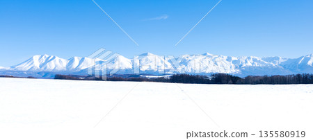 Winter blue sky and the majestic scenery of the Tokachi mountain range seen from the hills of Biei, Hokkaido 135580919