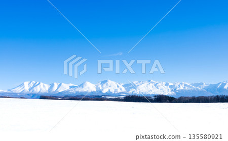 從北海道美瑛的山丘上眺望，冬日湛藍的天空和雄偉的十勝山脈盡收眼底。 135580921
