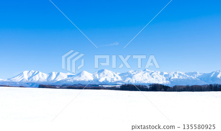 Winter blue sky and the majestic scenery of the Tokachi mountain range seen from the hills of Biei, Hokkaido 135580925