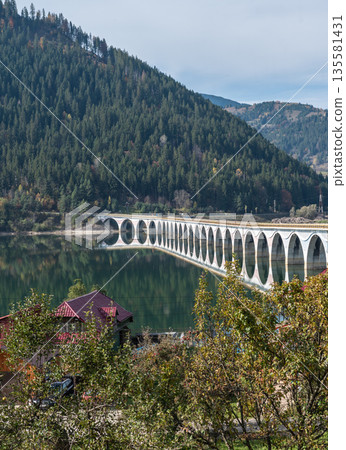 Scenic Arched Viaduct Crossing Lake Izvorul Muntelui In Romanian Mountains Scenic Arched Viaduct Crossing Lake Izvorul Muntelui In Romanian Mountains 135581431